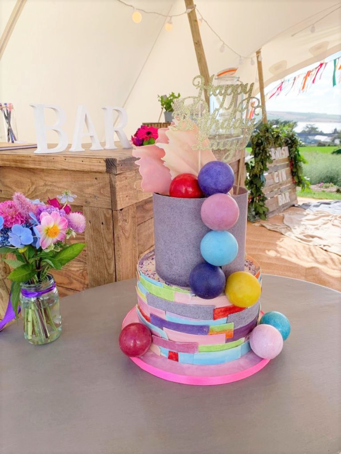 Birthday cake with chocolate popmpom balls and coloured bunting streamers