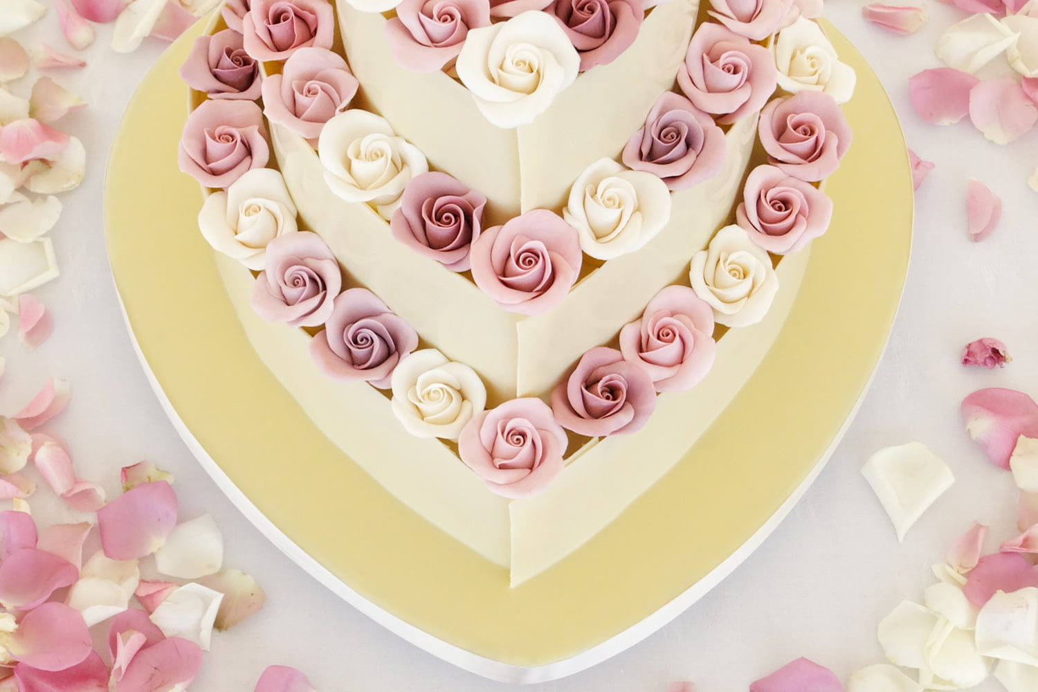 Three tier heart wedding cake with handmade sugar flowers close up