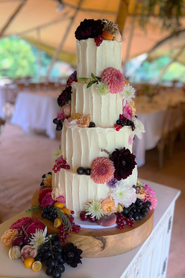 Vertical ribbed buttercream wedding cake with fruit and flowers