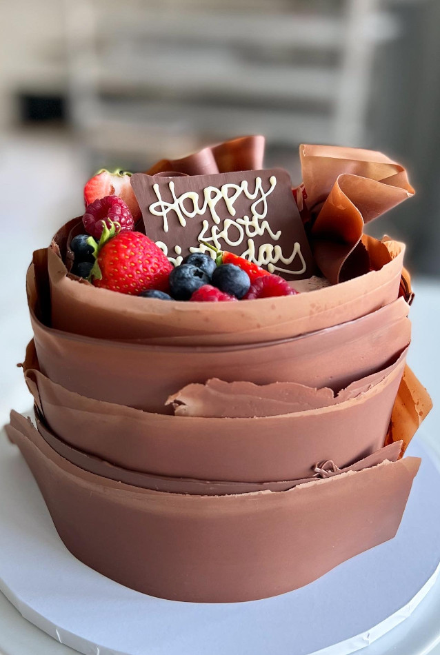 Milk chocolate wrapped cake with fresh berries