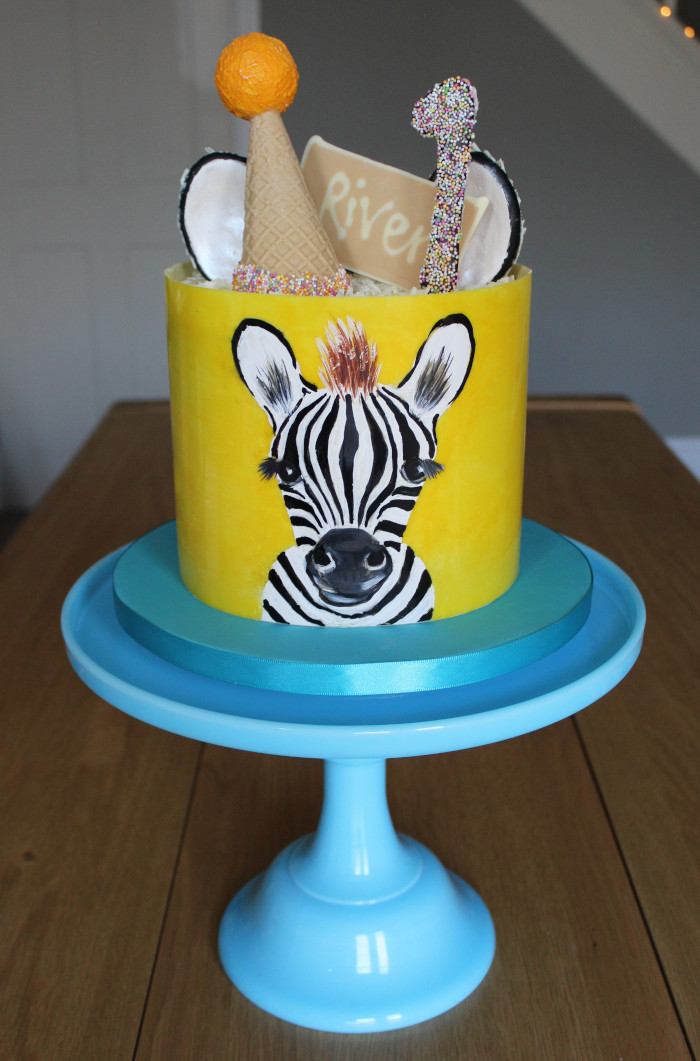Painted zebra cake on blue pedestal stand
